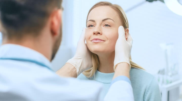 Dermatologist inspecting patient's face